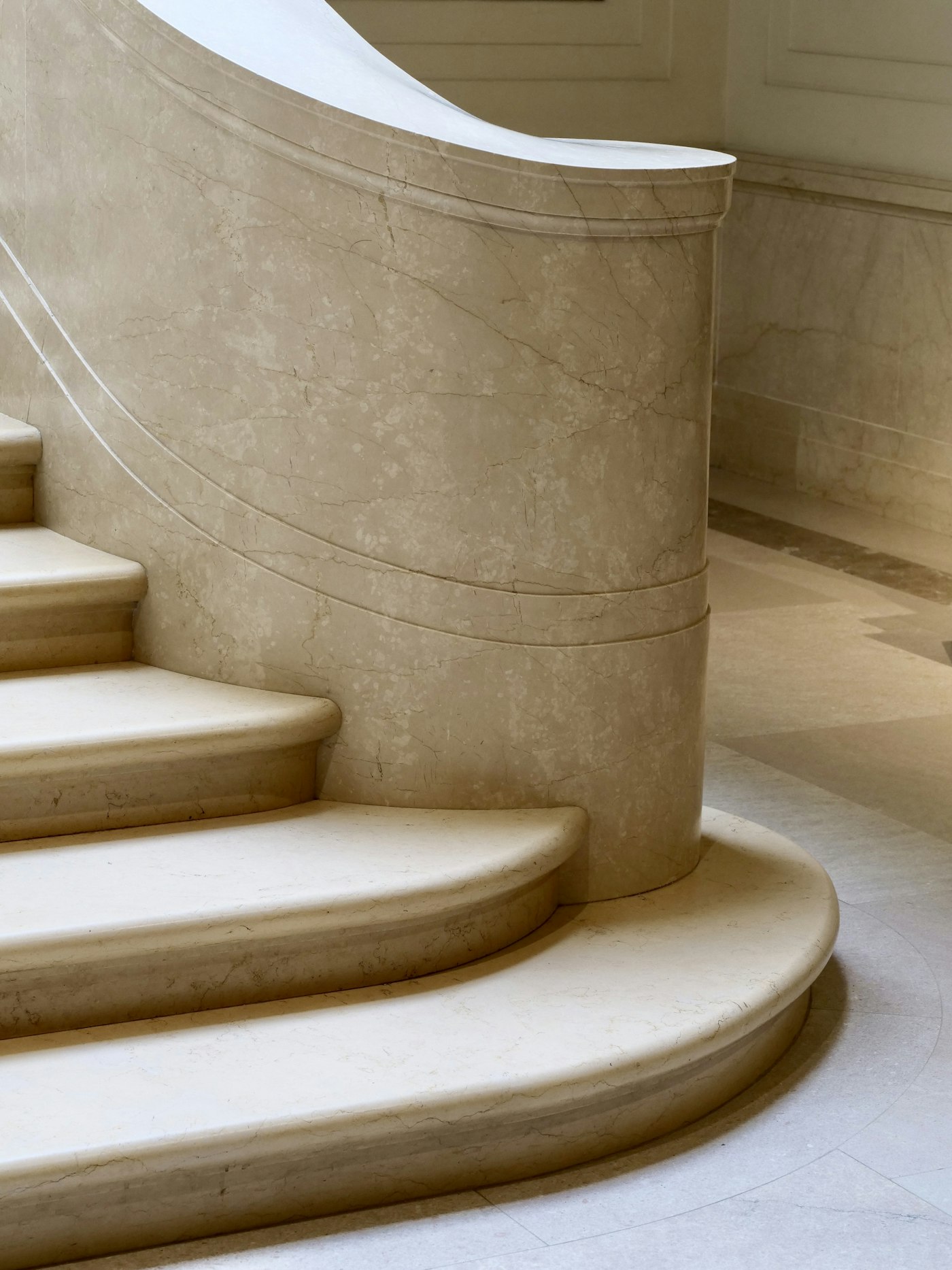 Curved marble staircase inside an elegant residence